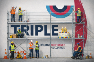 A diverse team of workers in hard hats and hi viz vests start to dismantle a TripleC logo on a wall. Around the site are tools, equipment and safety signs. They work from scaffolding and on one level is a huge cake with a number ten on it and lit candles.